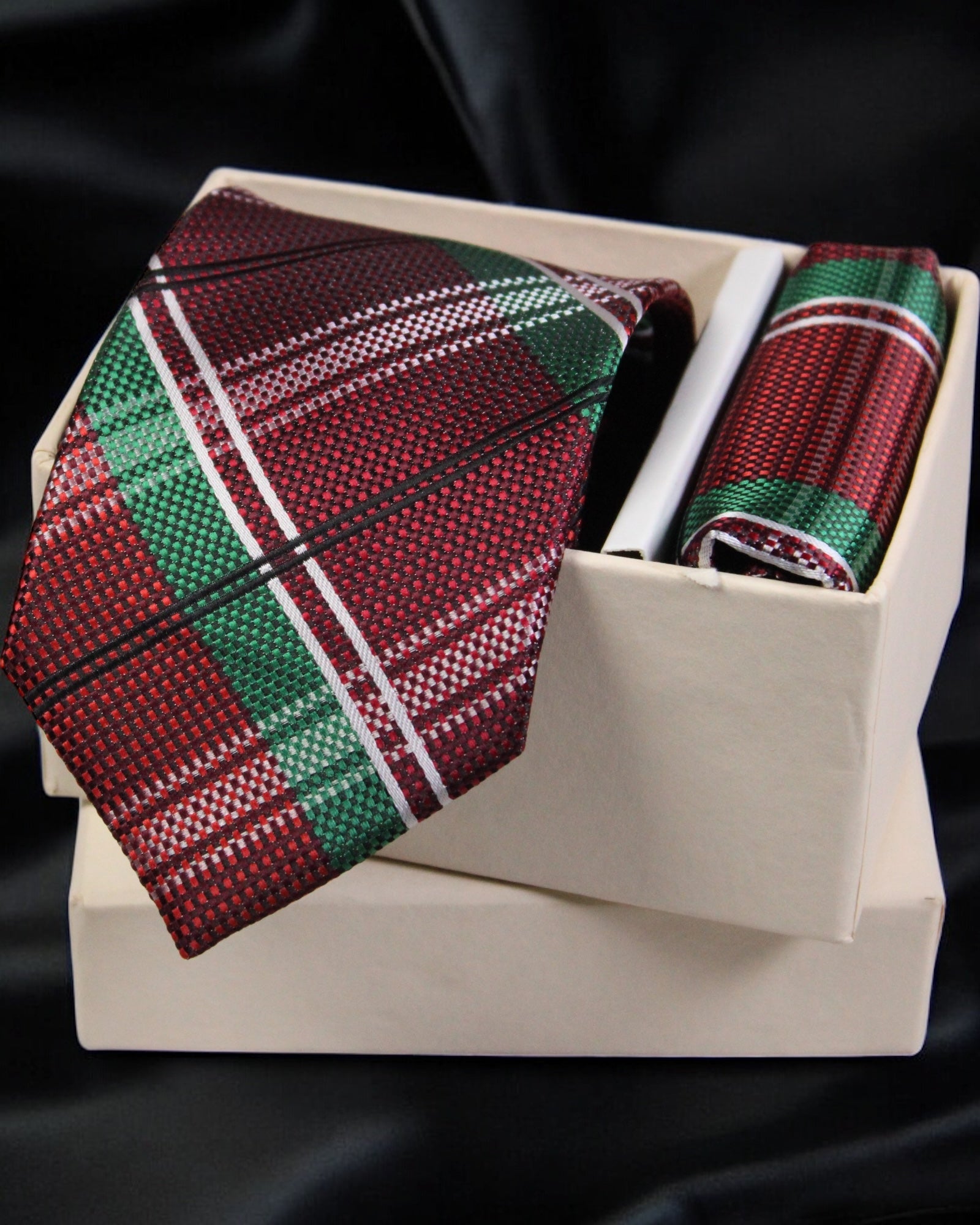 Red and green plaid tie and pocket square set in a box on a black background Tie Benon