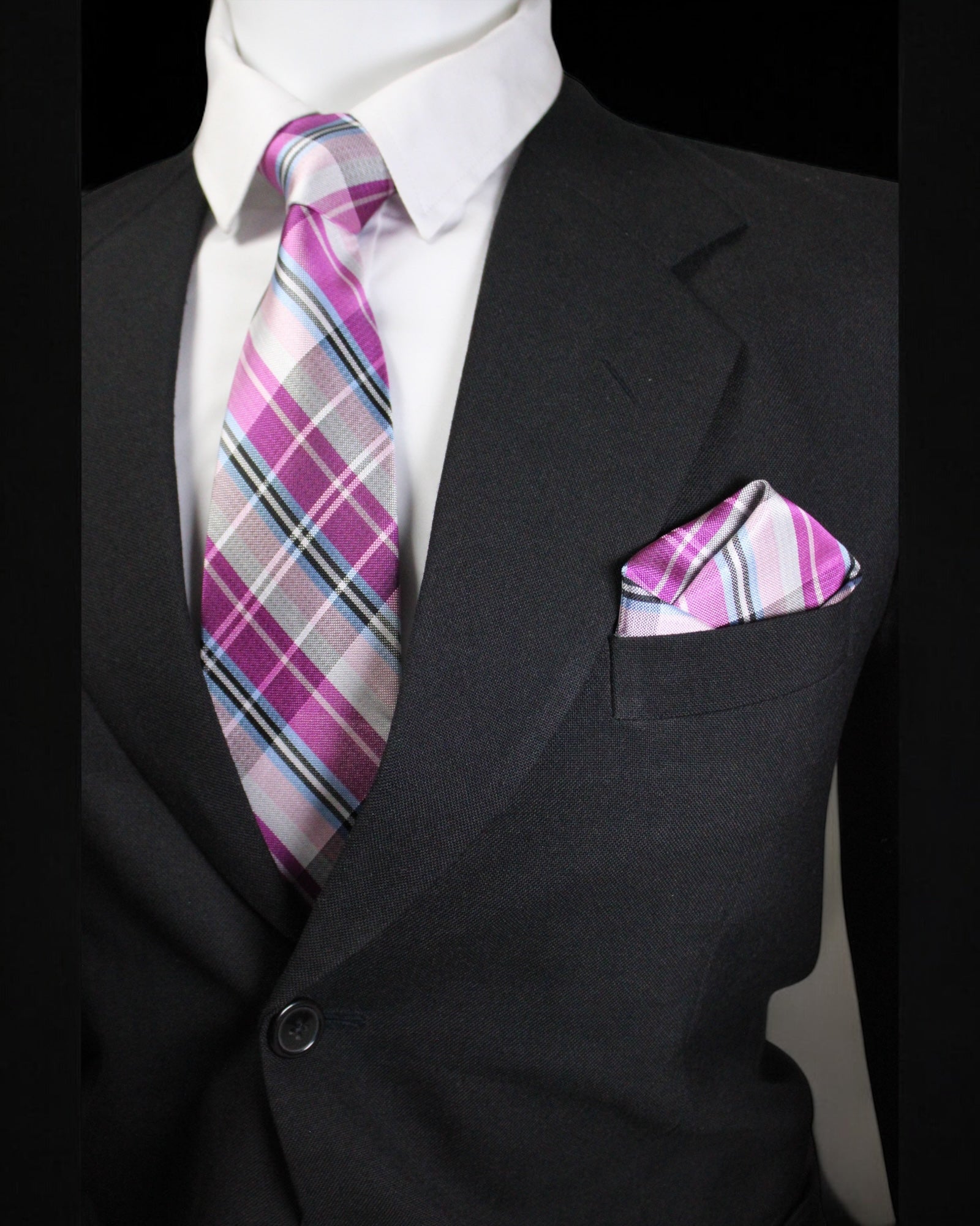 Black suit with a pink and gray plaid tie and pocket square on a dark background Tie Benon