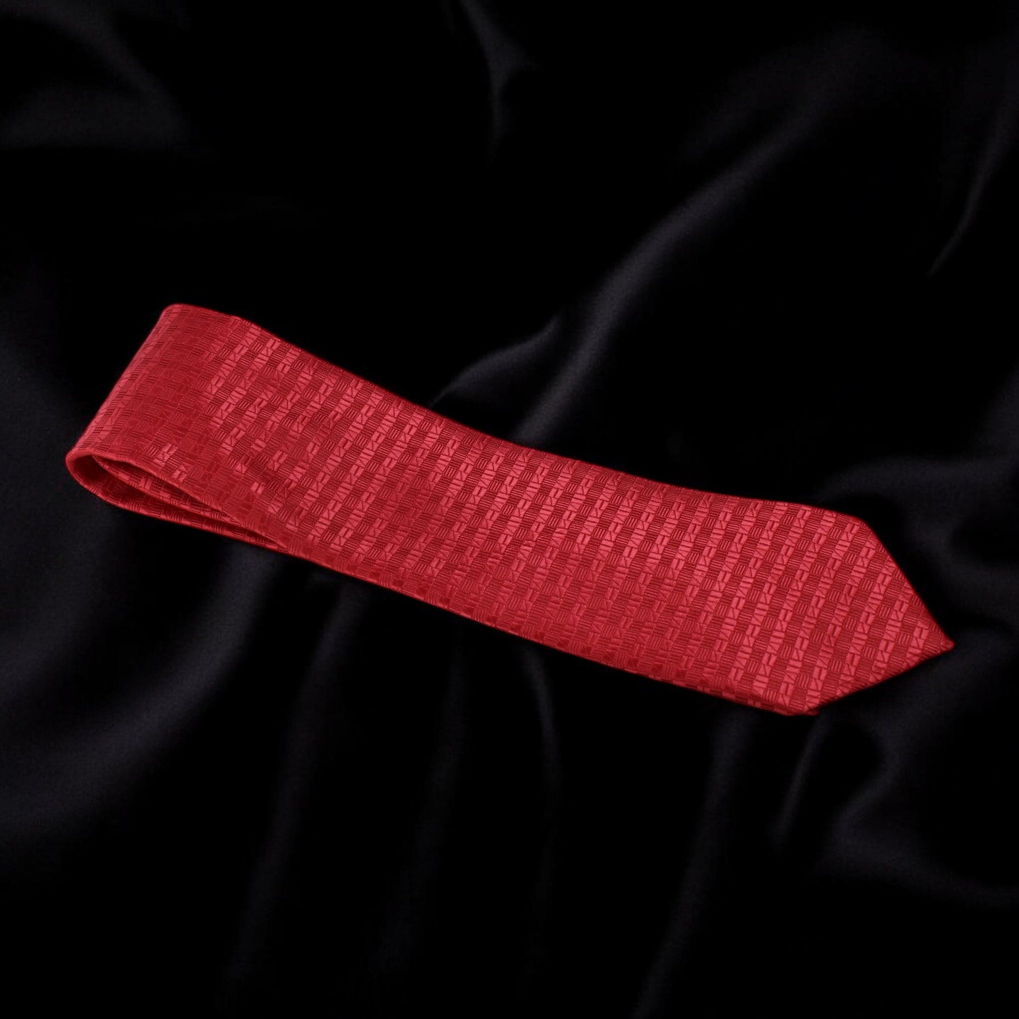 Red textured tie on black fabric background