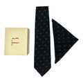 A black cashmere tie and pocket square combo with a geometric dot pattern, displayed with a letter 'T' on a yellow card and a small red box.