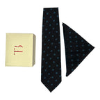 A black cashmere tie and pocket square combo with a geometric dot pattern, displayed with a letter 'T' on a yellow card and a small red box.