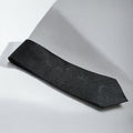 Black textured tie on a light gray background
