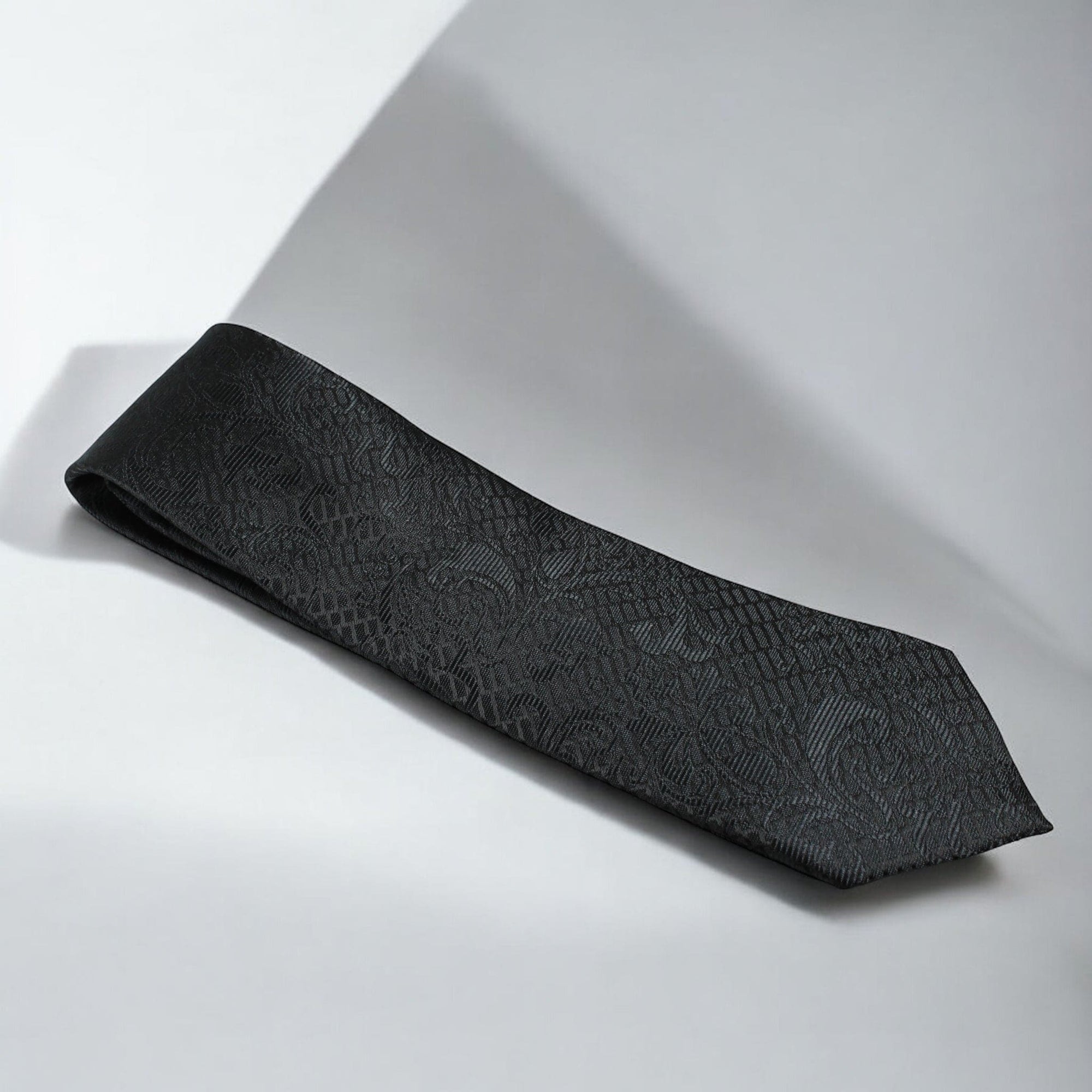 Black textured tie on a light gray background