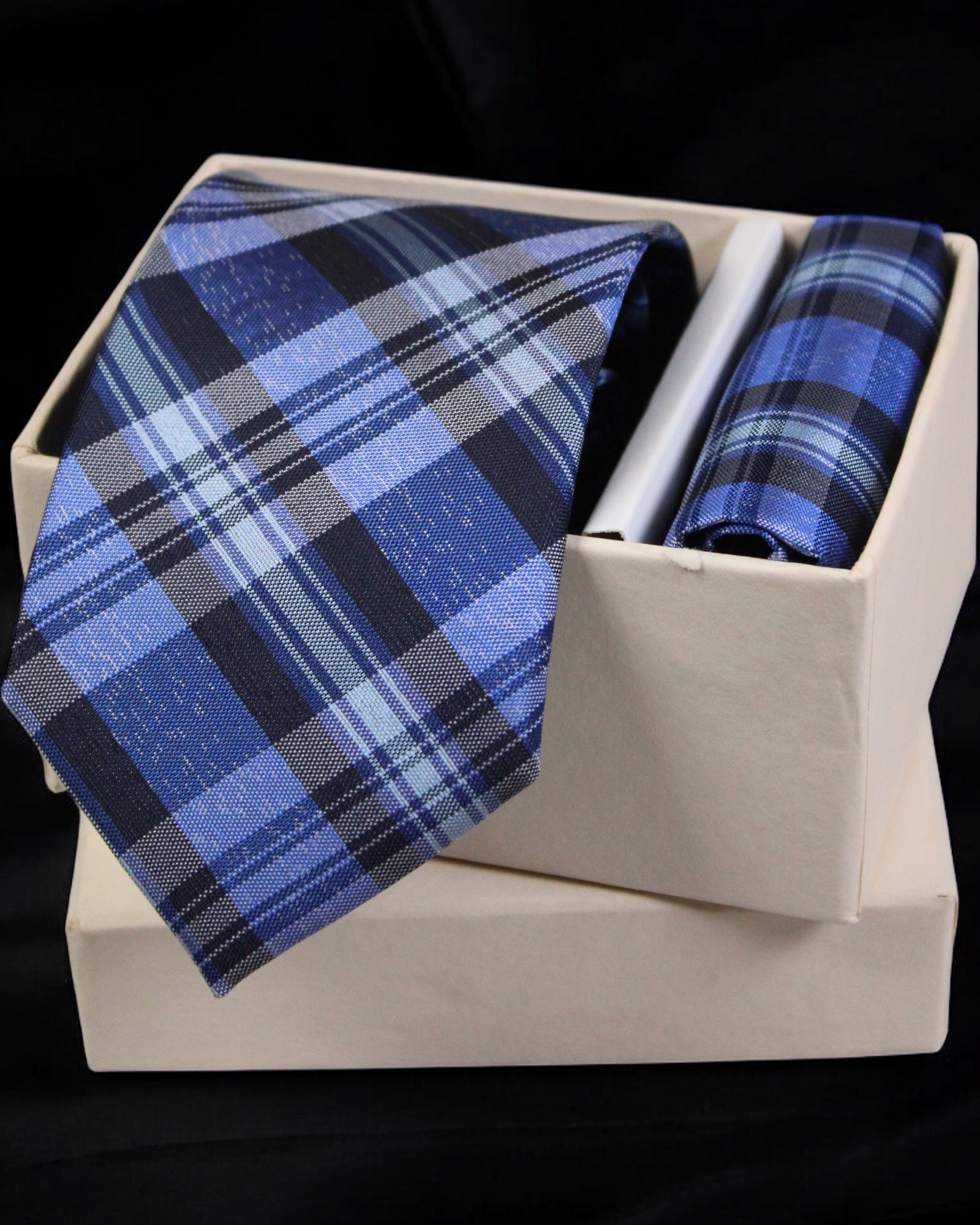 Blue plaid tie and pocket square set in a white box on a black background Tie Benon