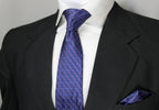 A photo showing a Blue & Purple Checkered Tie & Pocket Square set, with the tie worn in a standard knot and the pocket square placed in the breast pocket of a suit jacket.