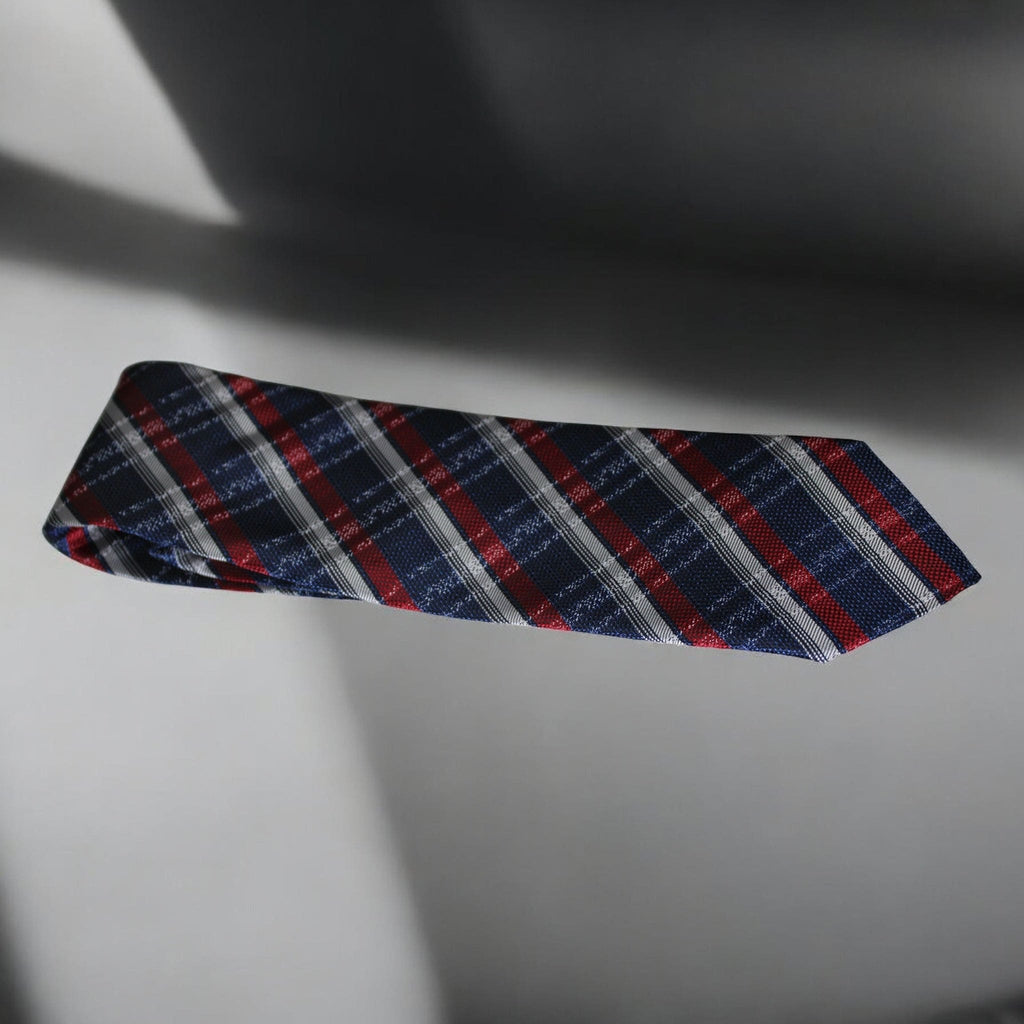 Plaid tie with red, blue, and gray pattern on a light background