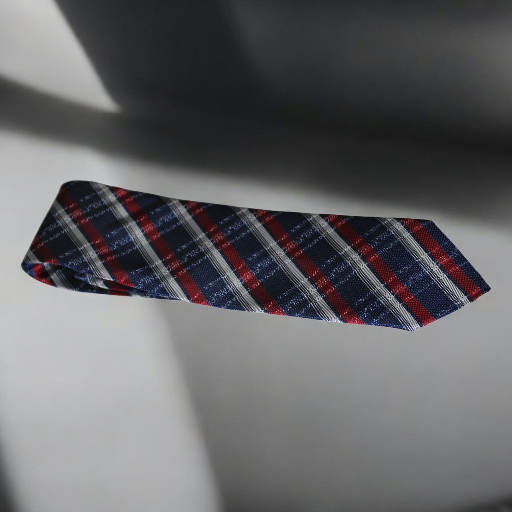 Plaid tie with red, blue, and gray pattern on a light background