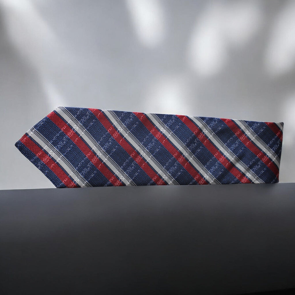 Striped tie with red, blue, and gray pattern on a dark surface