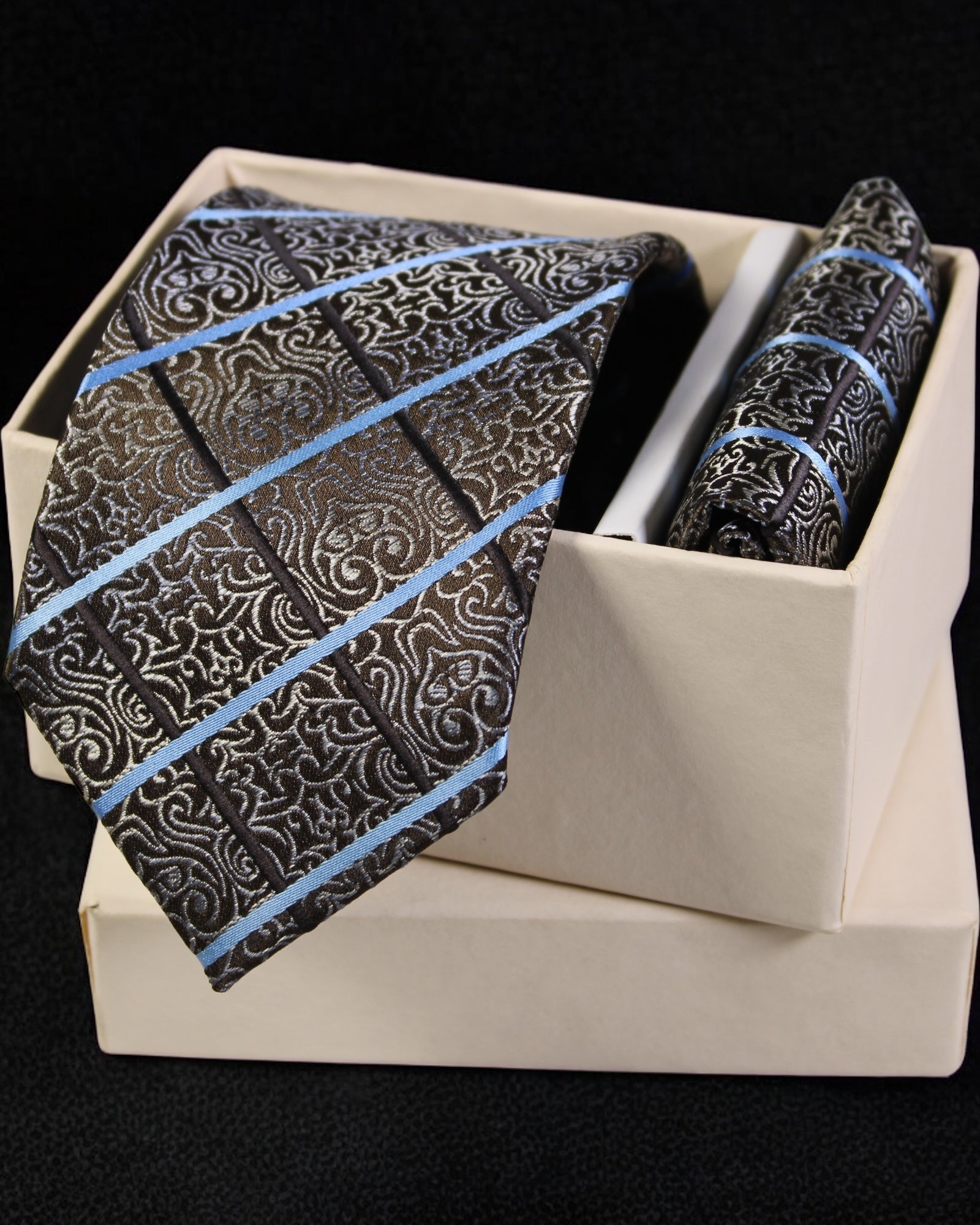 Black paisley tie with blue stripes and matching pocket square in a white box on a black background Tie Benon