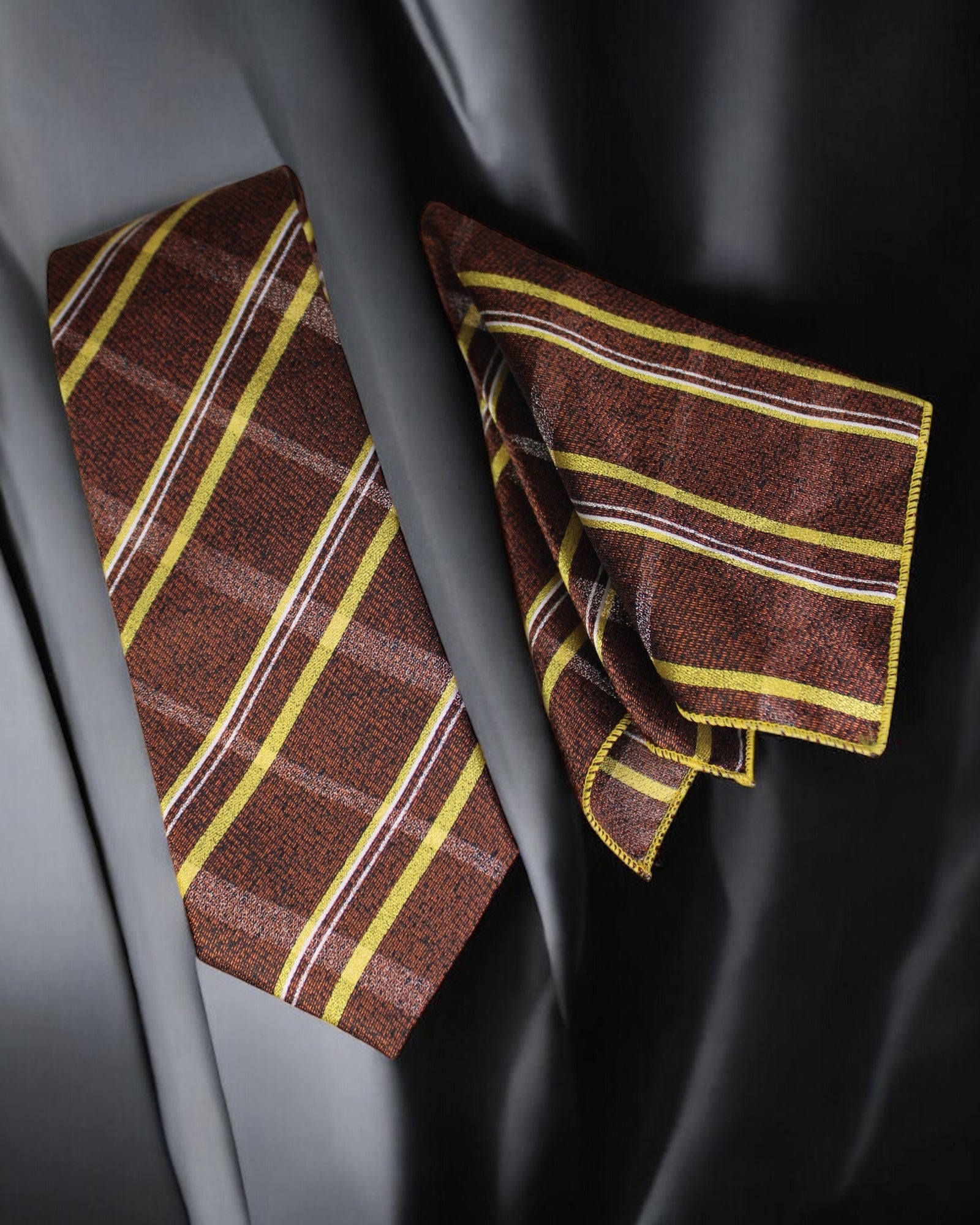 Brown and yellow striped tie and pocket square on a dark background tie benon