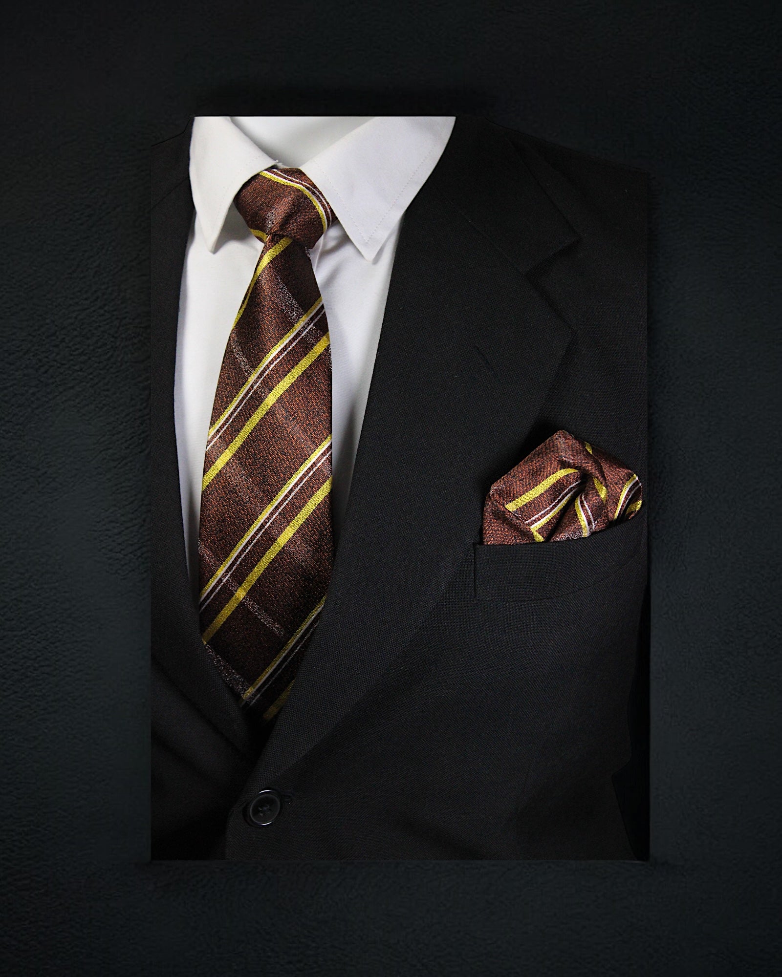 Black suit with a white shirt, brown and yellow striped tie, and matching pocket square on a black background Tie Benon
