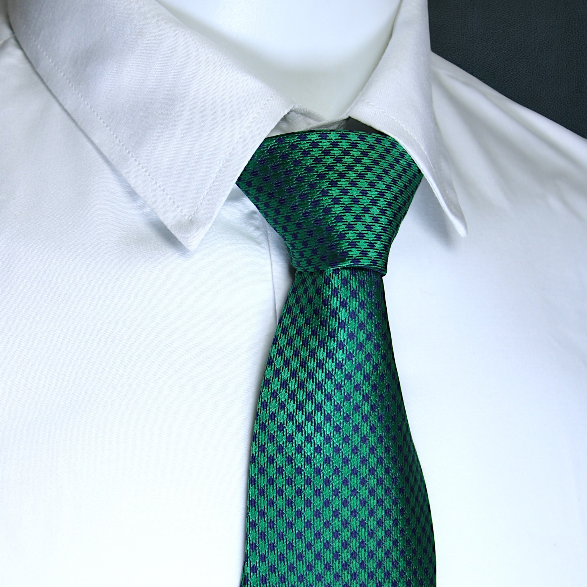 Green checkered tie on a white shirt with a black background