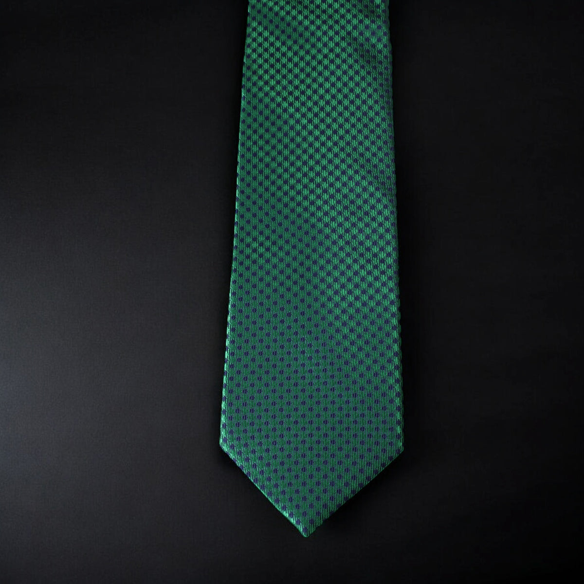 Green patterned tie on a black background