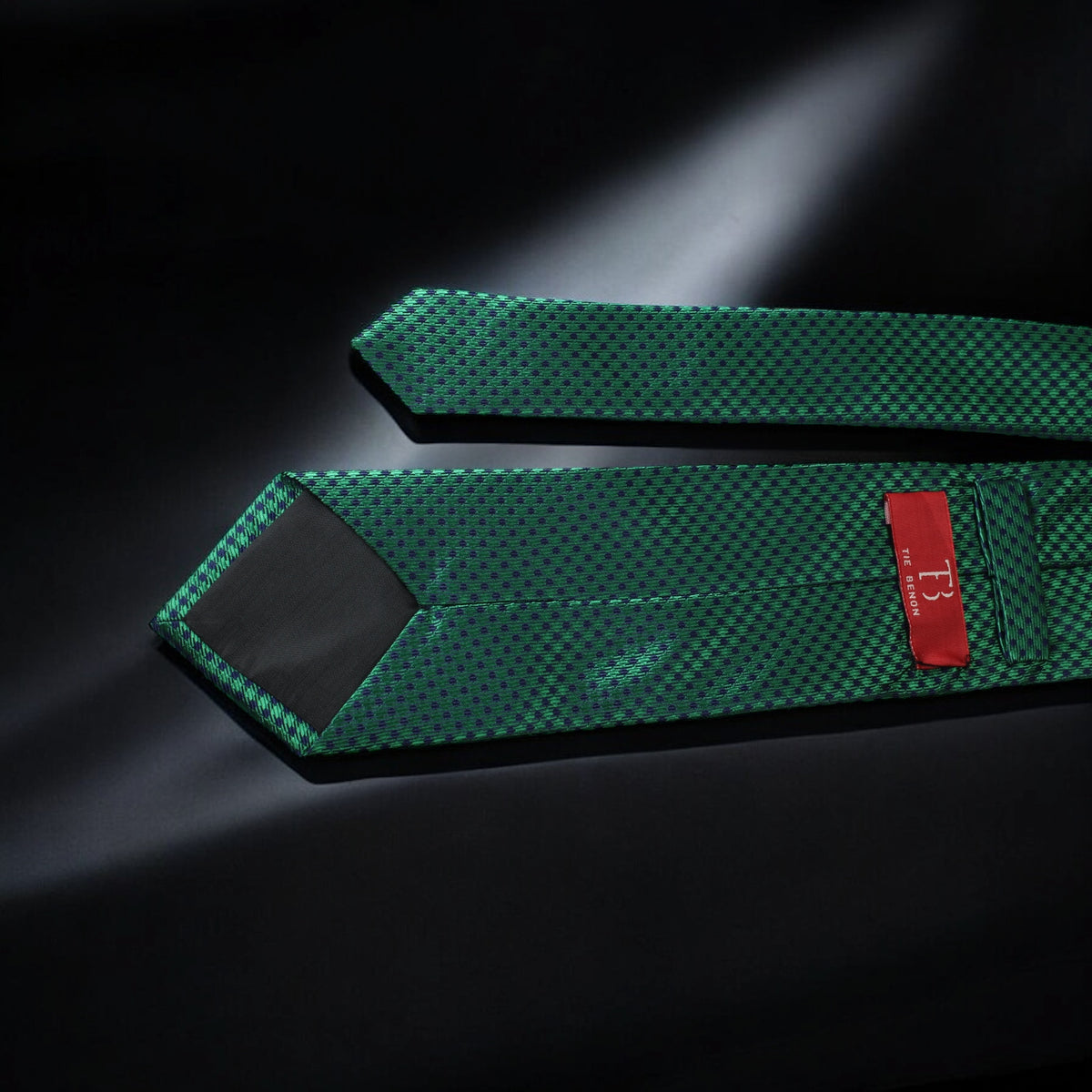 Two green textured straps with a red label on a dark background