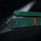 Two green textured straps with a red label on a dark background