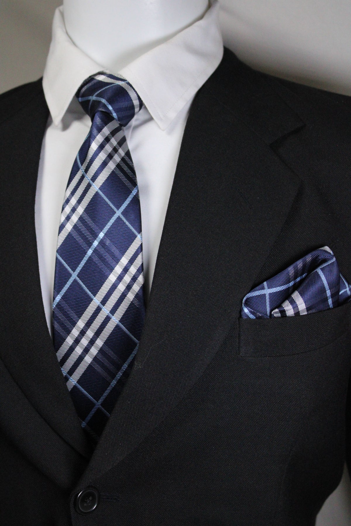 Close-up of a blue plaid tie and pocket square on a suit jacket tie benon