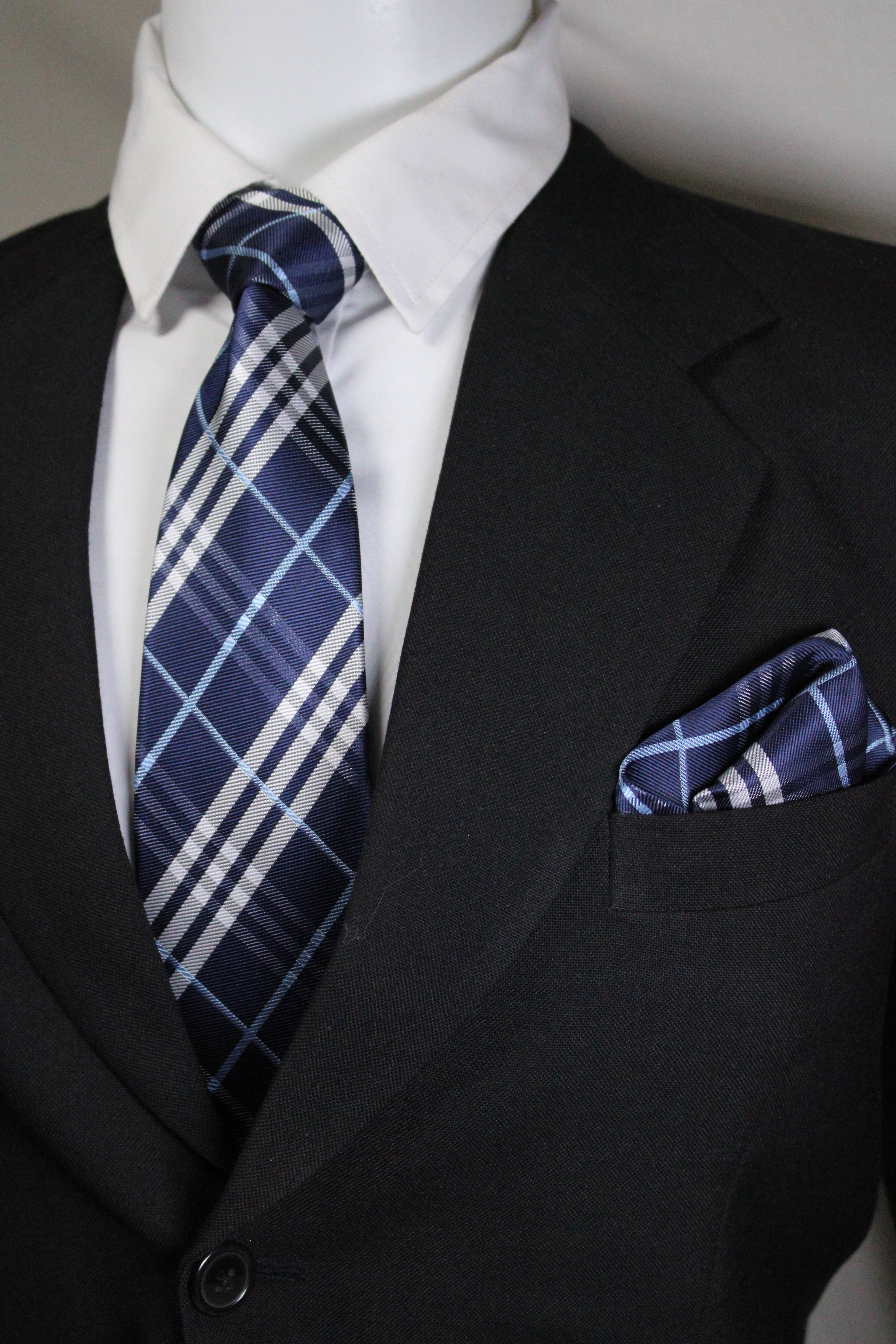 Close-up of a blue plaid tie and pocket square on a suit jacket tie benon