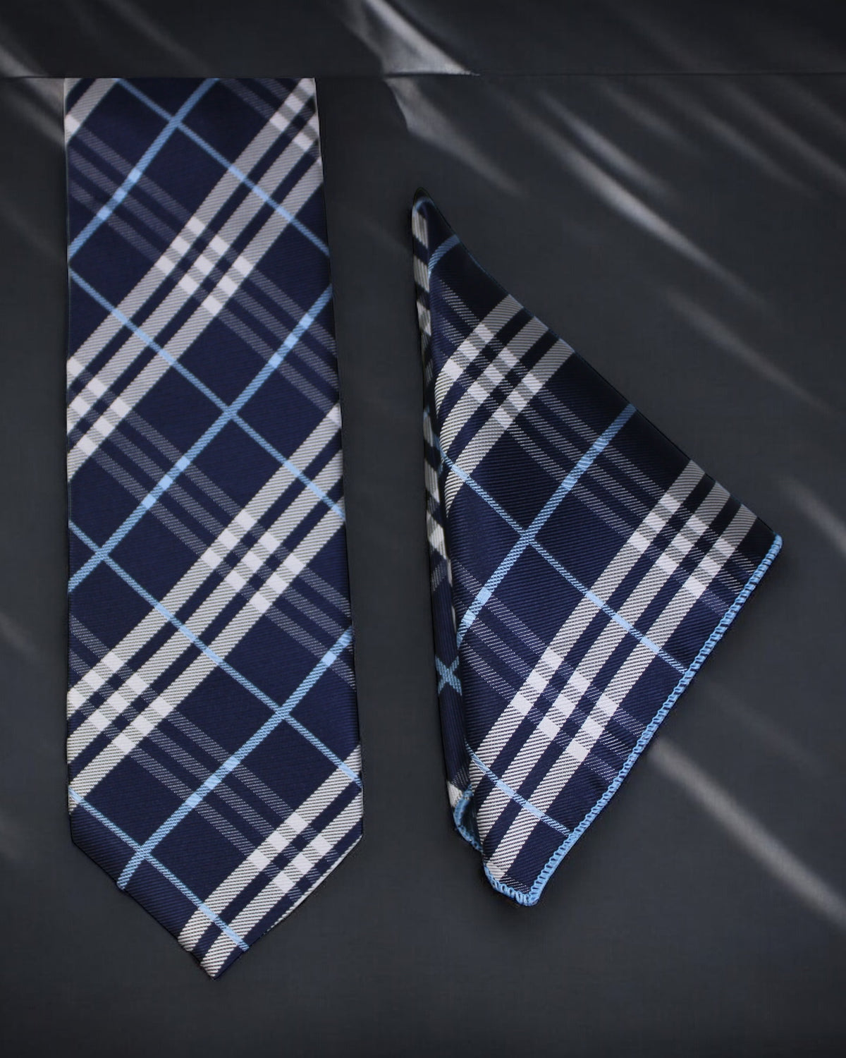 Navy and white plaid tie and pocket square on a dark background tie benon
