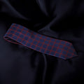 Blue and red checkered tie on a dark fabric background
