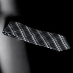 Black and gray plaid tie on a black background