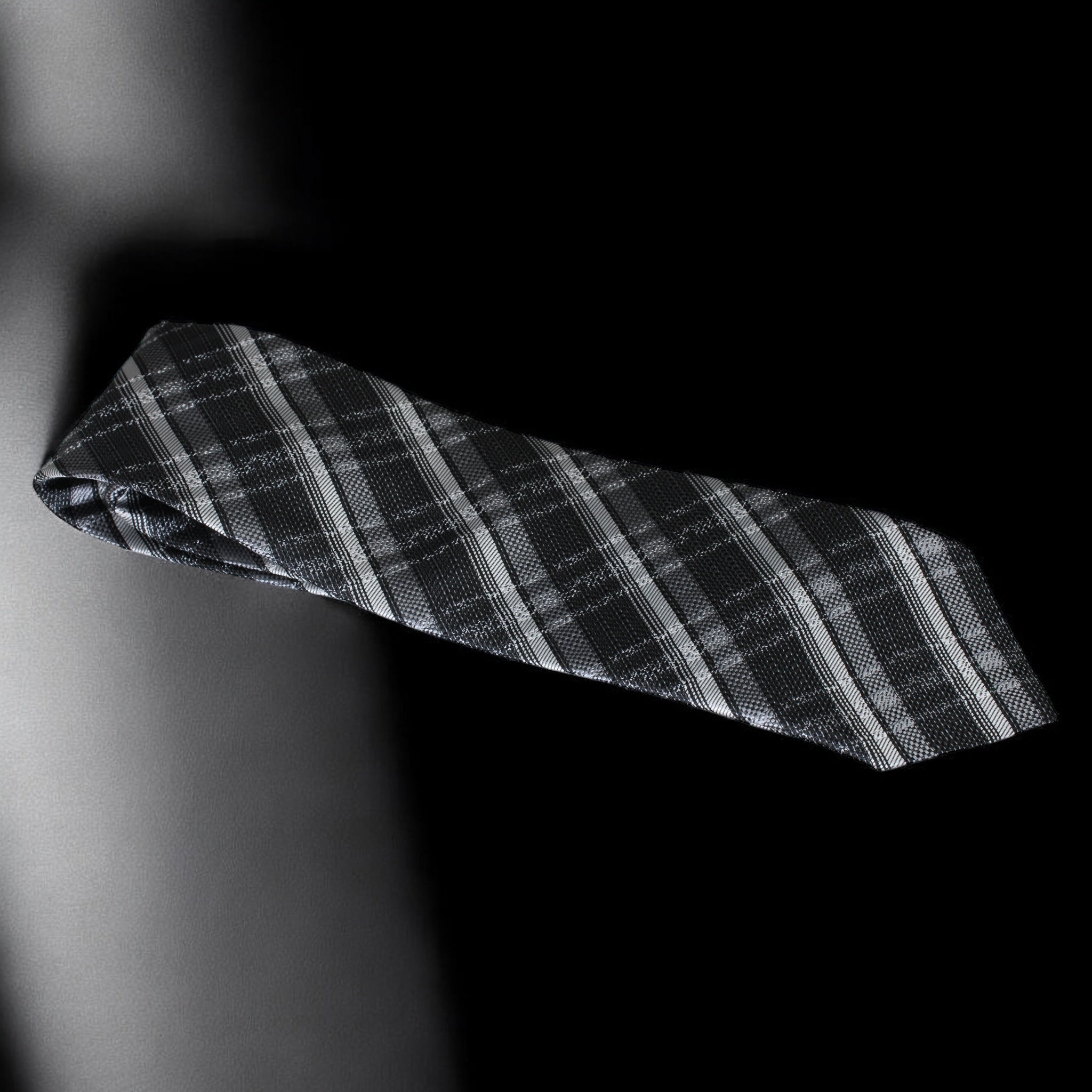 Black and gray plaid tie on a black background