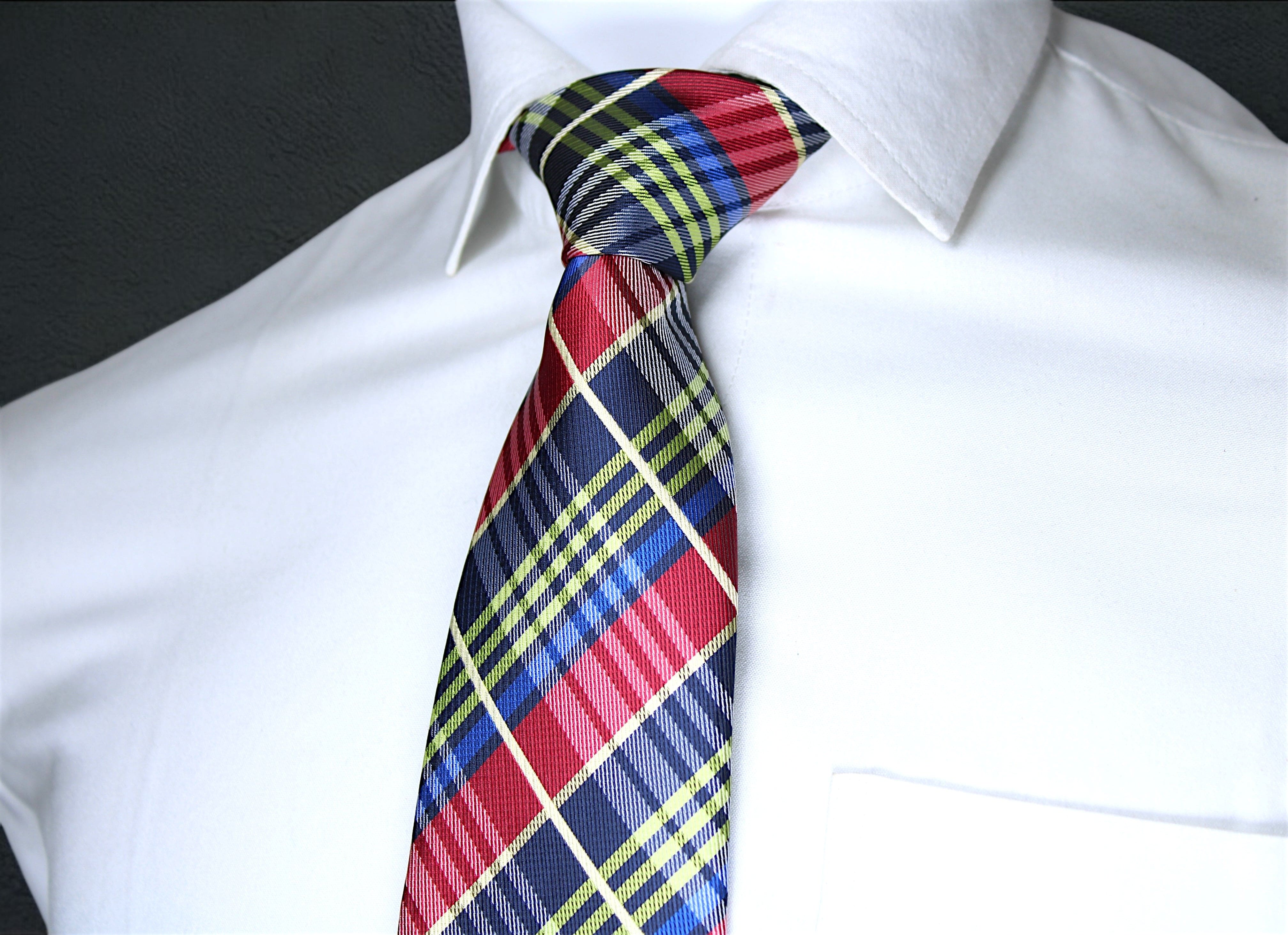 Colorful plaid tie on a white shirt against a black background