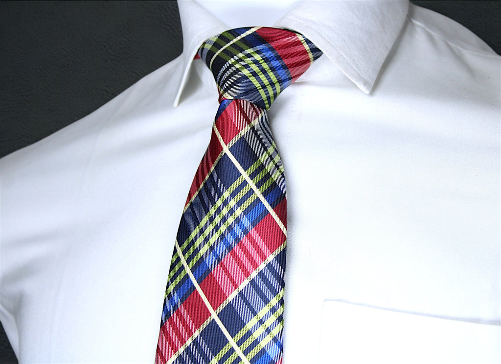 Colorful plaid tie on a white shirt against a black background