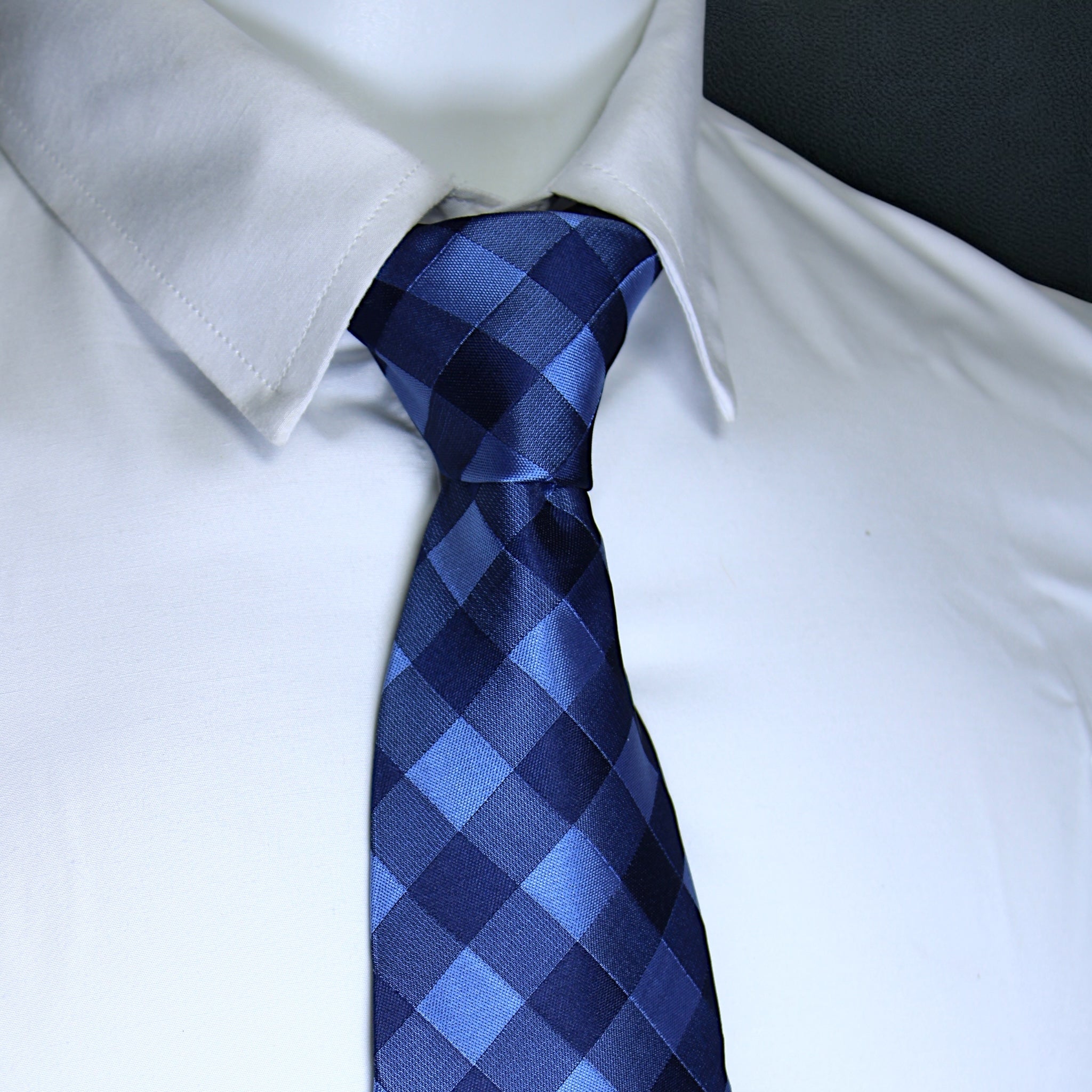 Blue checkered tie on a white shirt with a blurred background