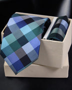 Blue and green checkered tie with matching pocket square in a box on a black background Tie Benon