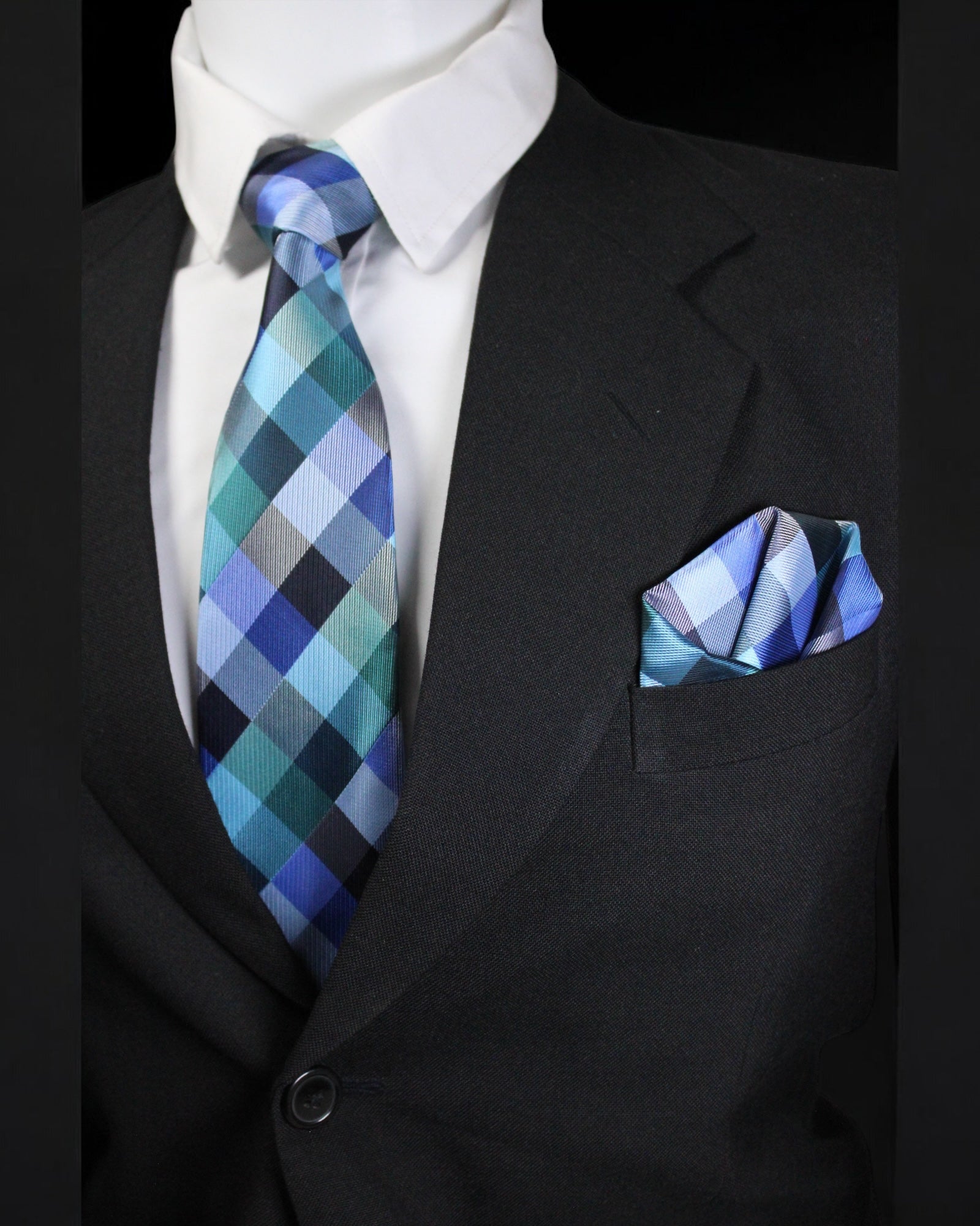 Black suit with a blue and green checkered tie and pocket square Tie Benon