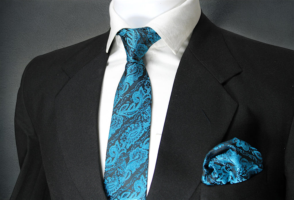 A blue paisley tie with a pocket square, displayed on a mannequin wearing a black suit and white shirt.