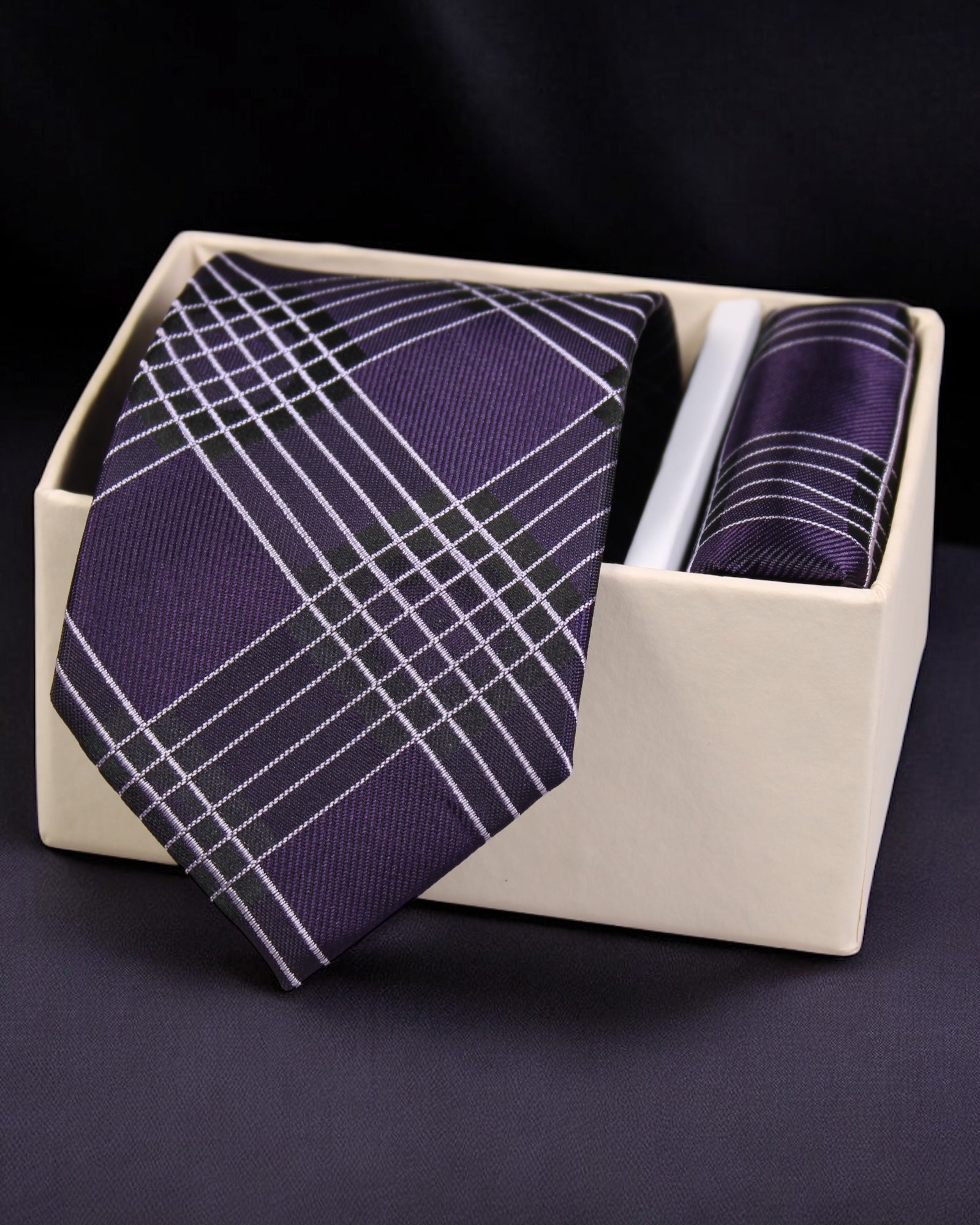 Purple plaid tie and pocket square set in a white box on a dark background Tie Benon