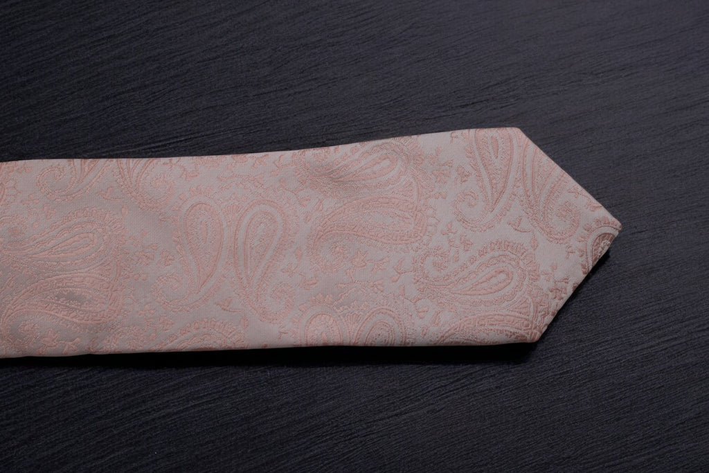 Pink paisley tie on a dark surface