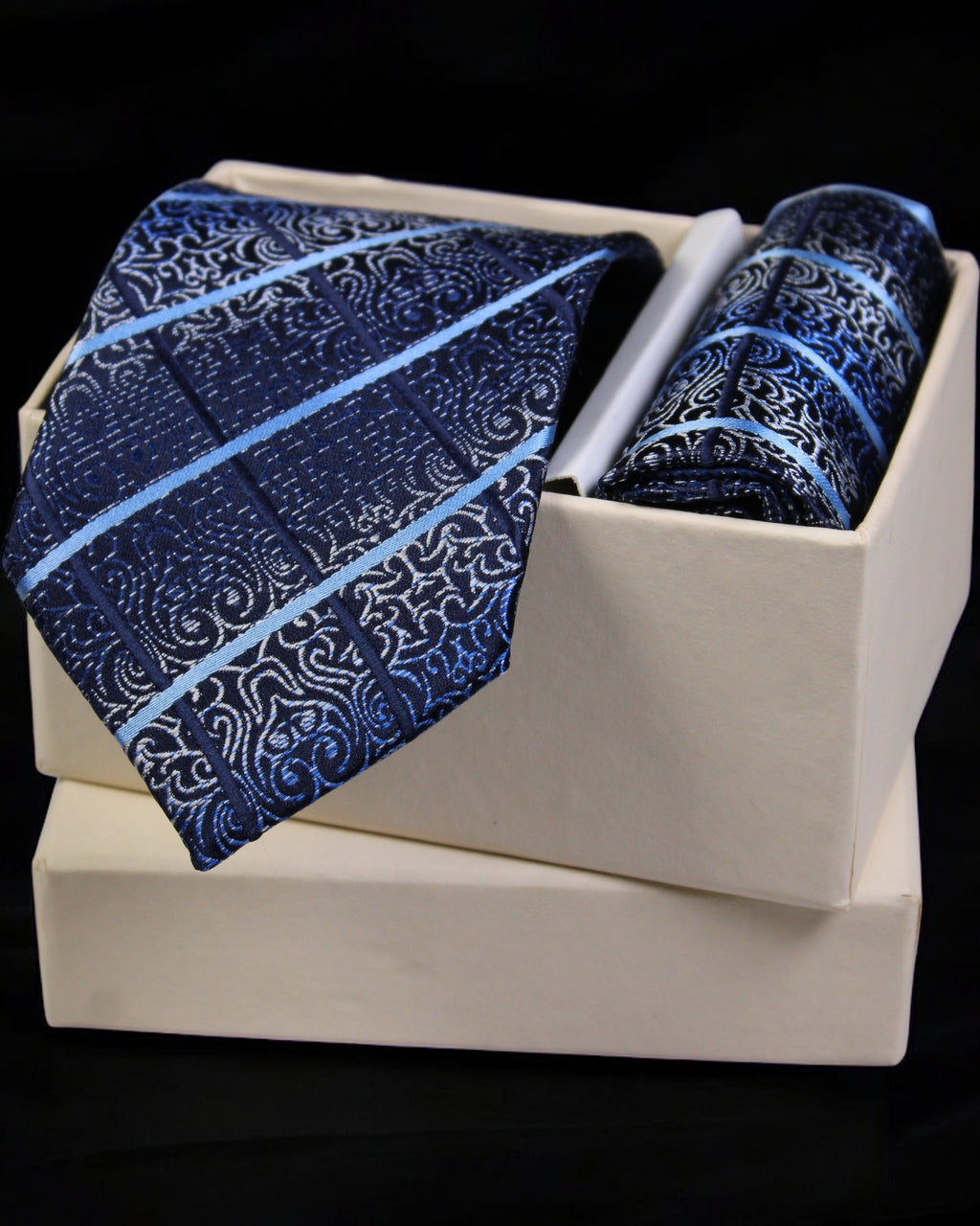 Blue patterned tie and pocket square set in a white box on a black background tie Benon
