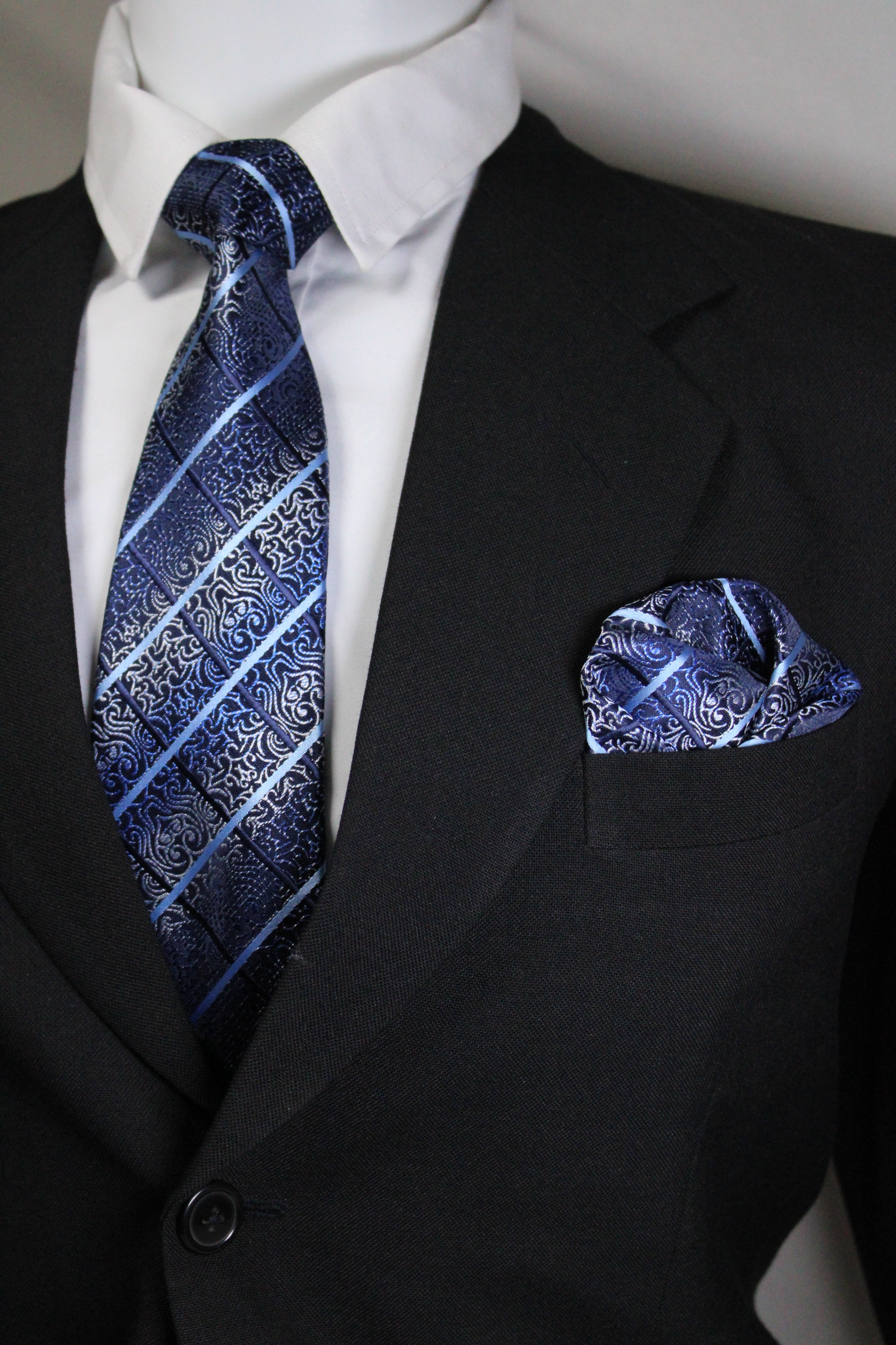 Blue patterned tie and pocket square on a black suit jacket Tie Benon