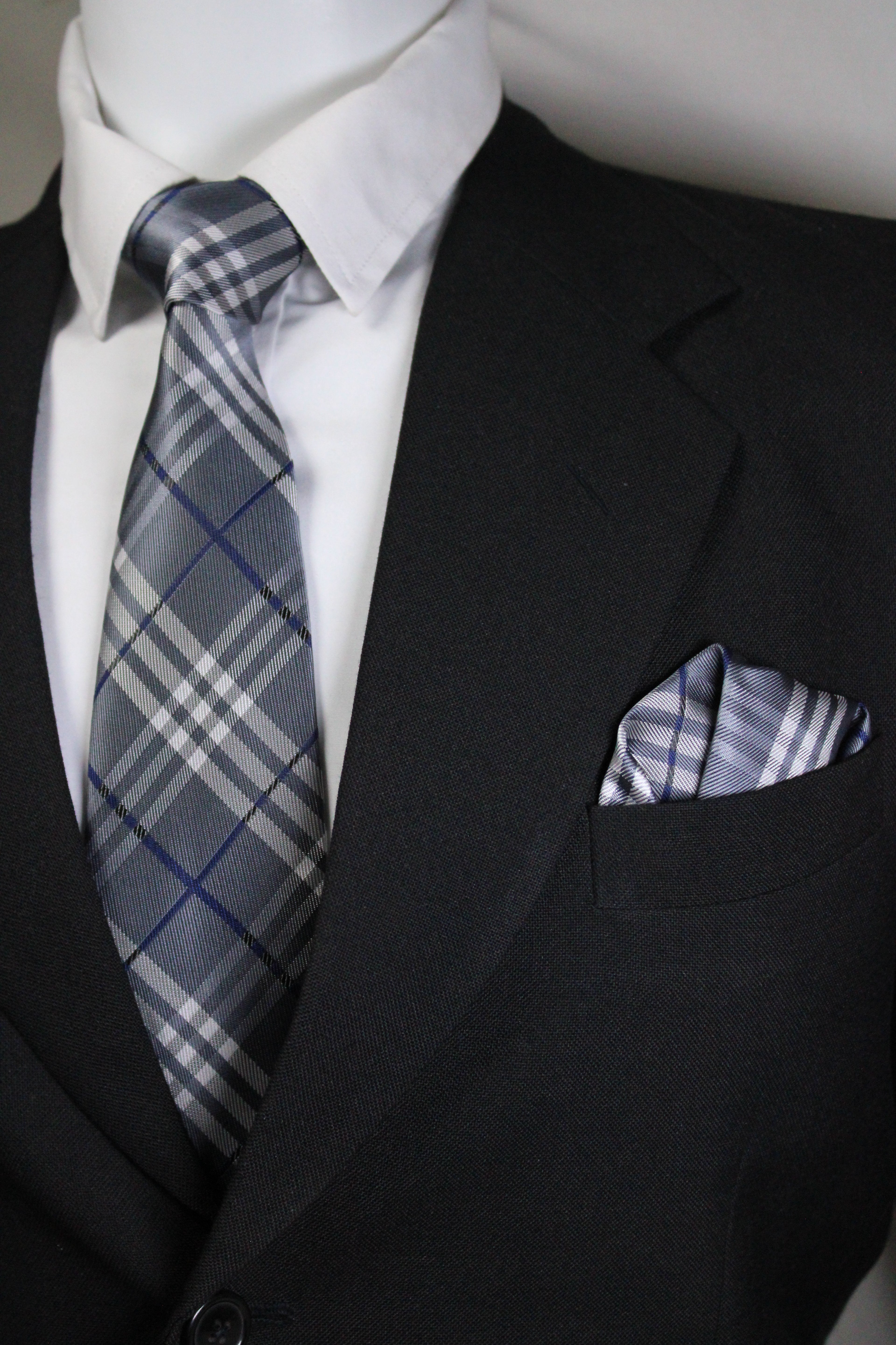 Close-up of a plaid tie and pocket square with a suit jacket Tie benon