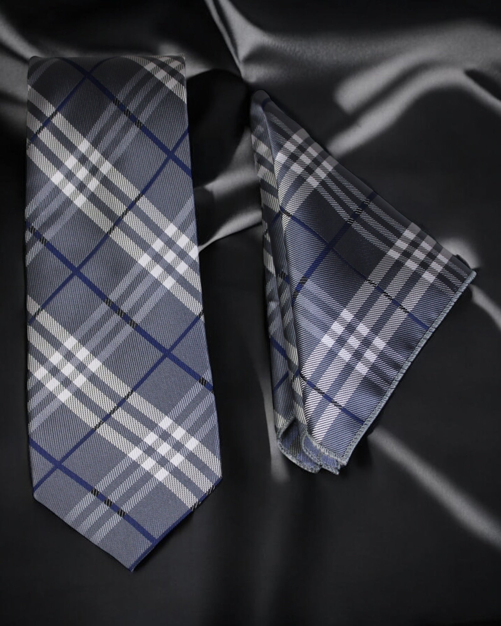 Plaid tie and matching pocket square on a dark fabric background Tie Benon