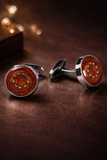 Pair of cufflinks with brown circular design on a dark surface