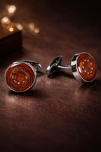 Pair of cufflinks with brown circular design on a dark surface
