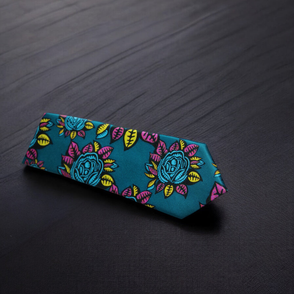 A dark sea green necktie with a floral pattern in pink and yellow, displayed on a dark background.