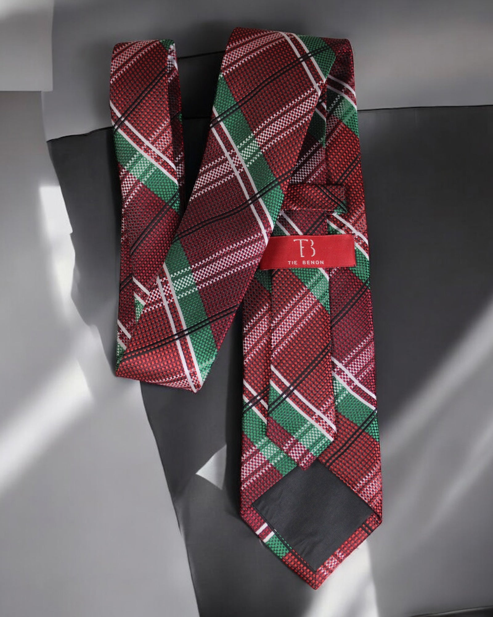 Red and green plaid tie with a red tag on a gray background Tie Benon