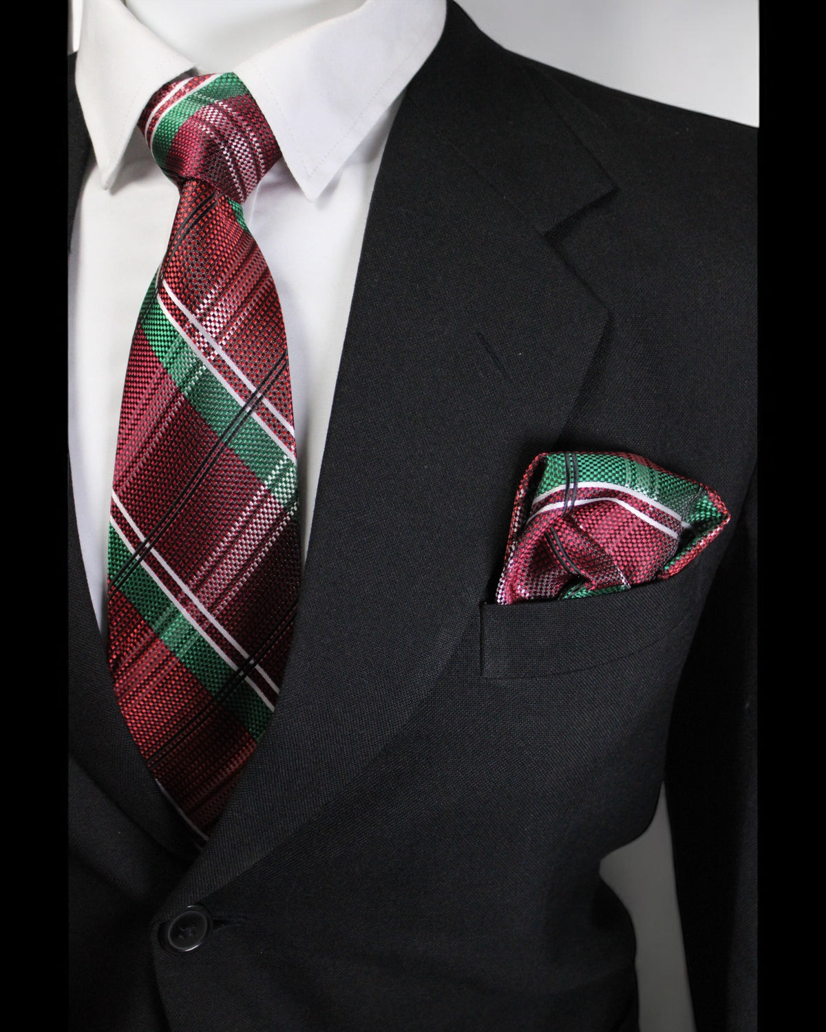 Black suit with a red and green plaid tie and matching pocket square on a white background Tie Benon