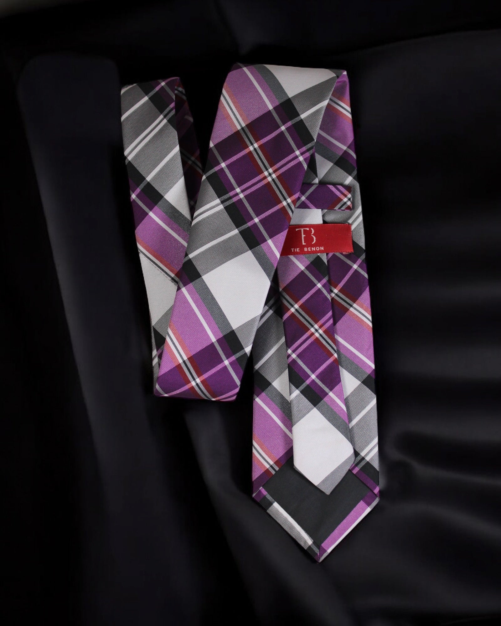 Plaid tie with a brand label on a black background Tie Benon