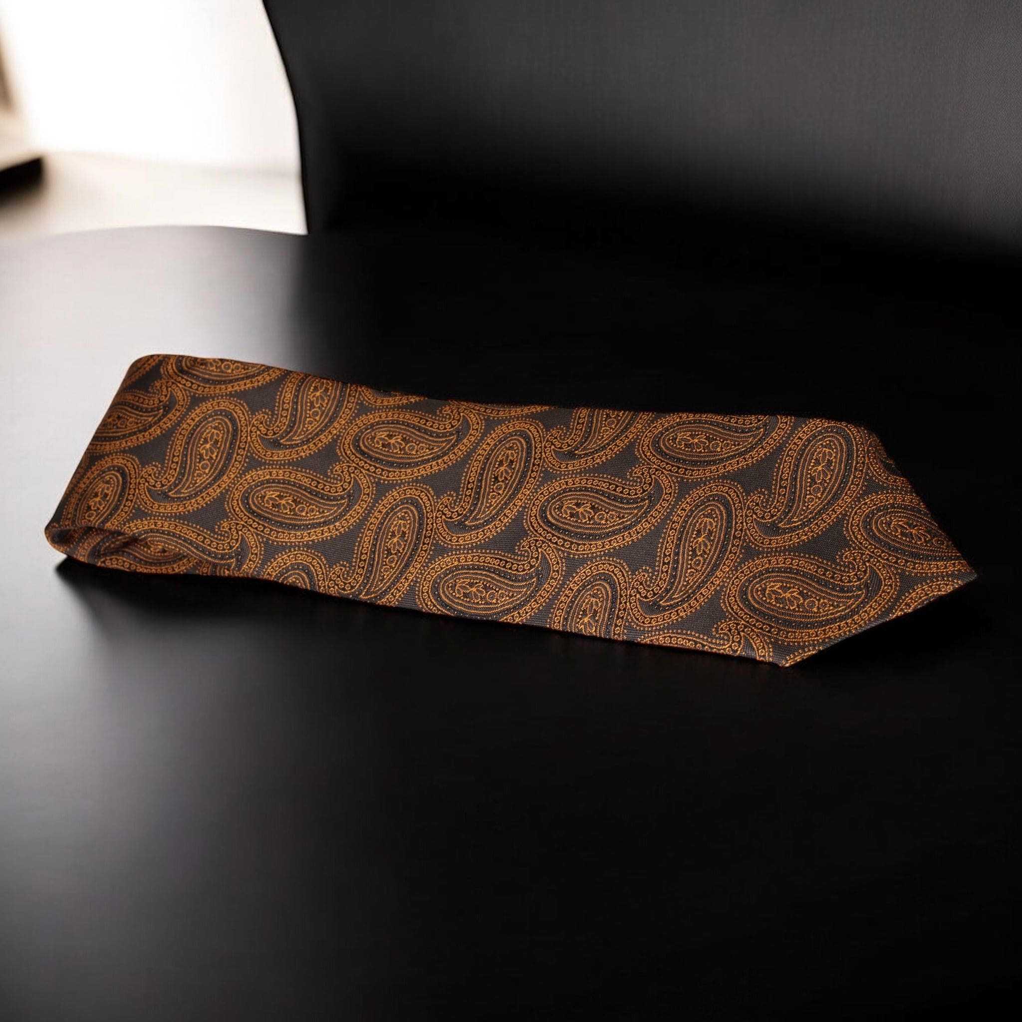 Brown paisley patterned tie on a black background