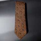 Brown paisley patterned tie on a gray background