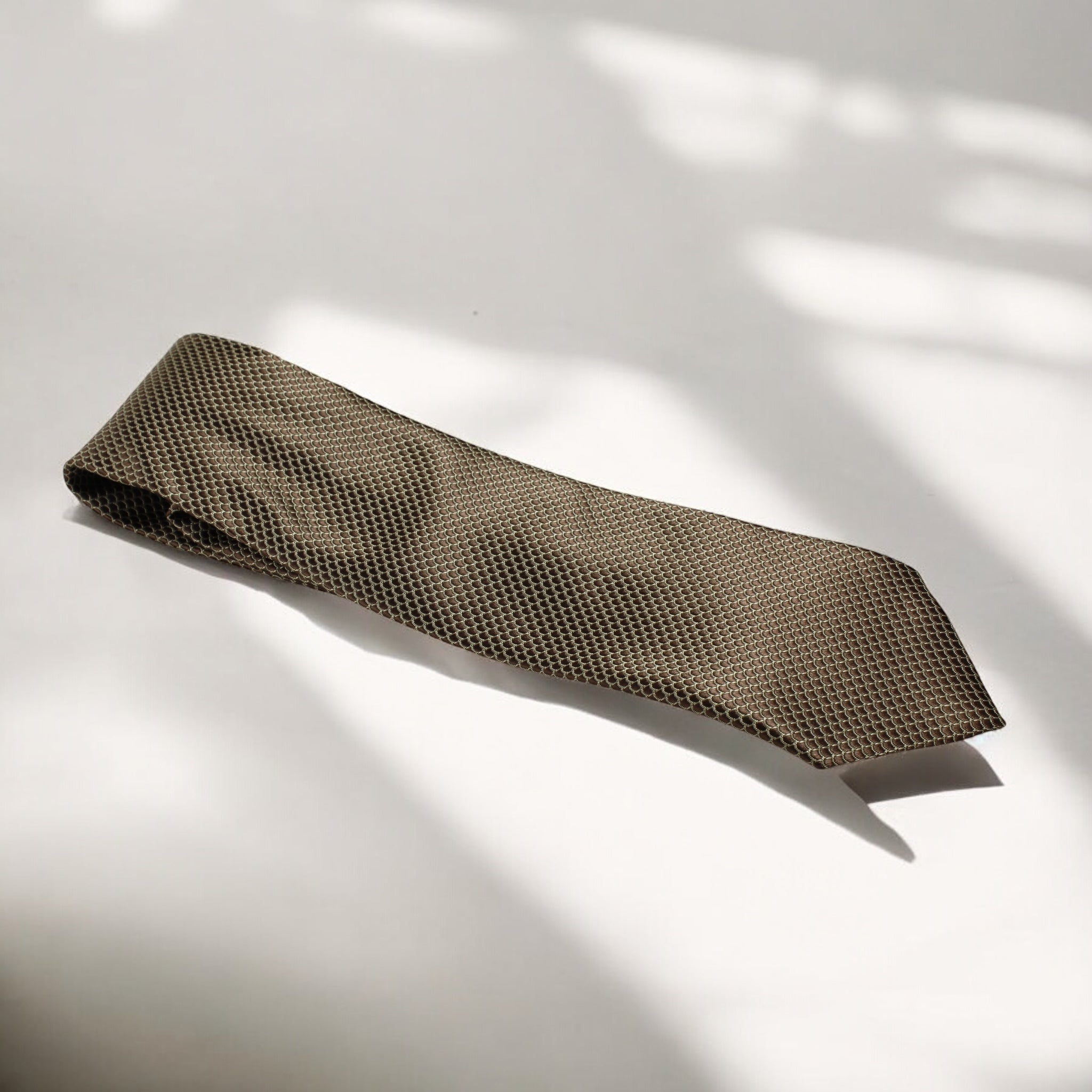 Brown patterned tie on a light gray background