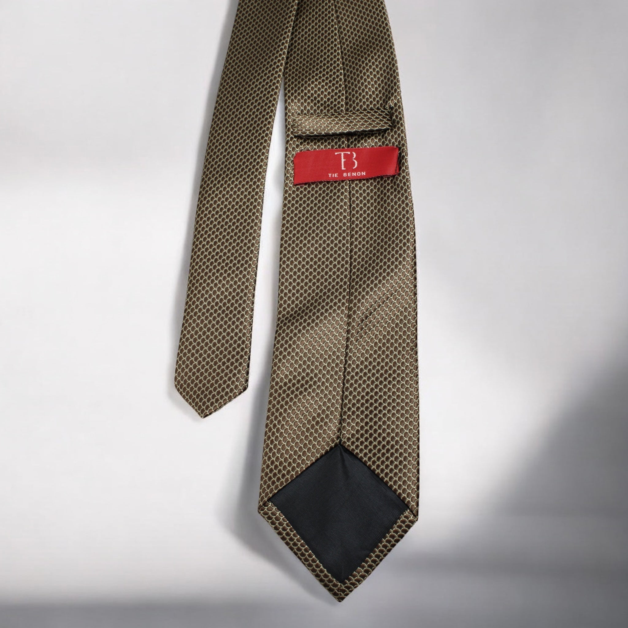 Brown patterned tie with a red label on a light gray background