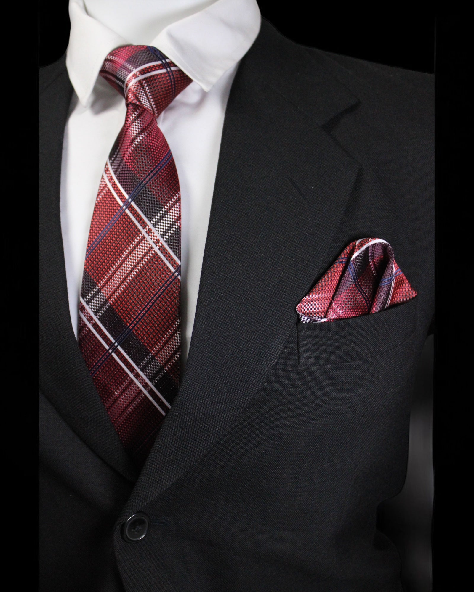 Black suit with a red plaid tie and pocket square on a white background Tie Benon