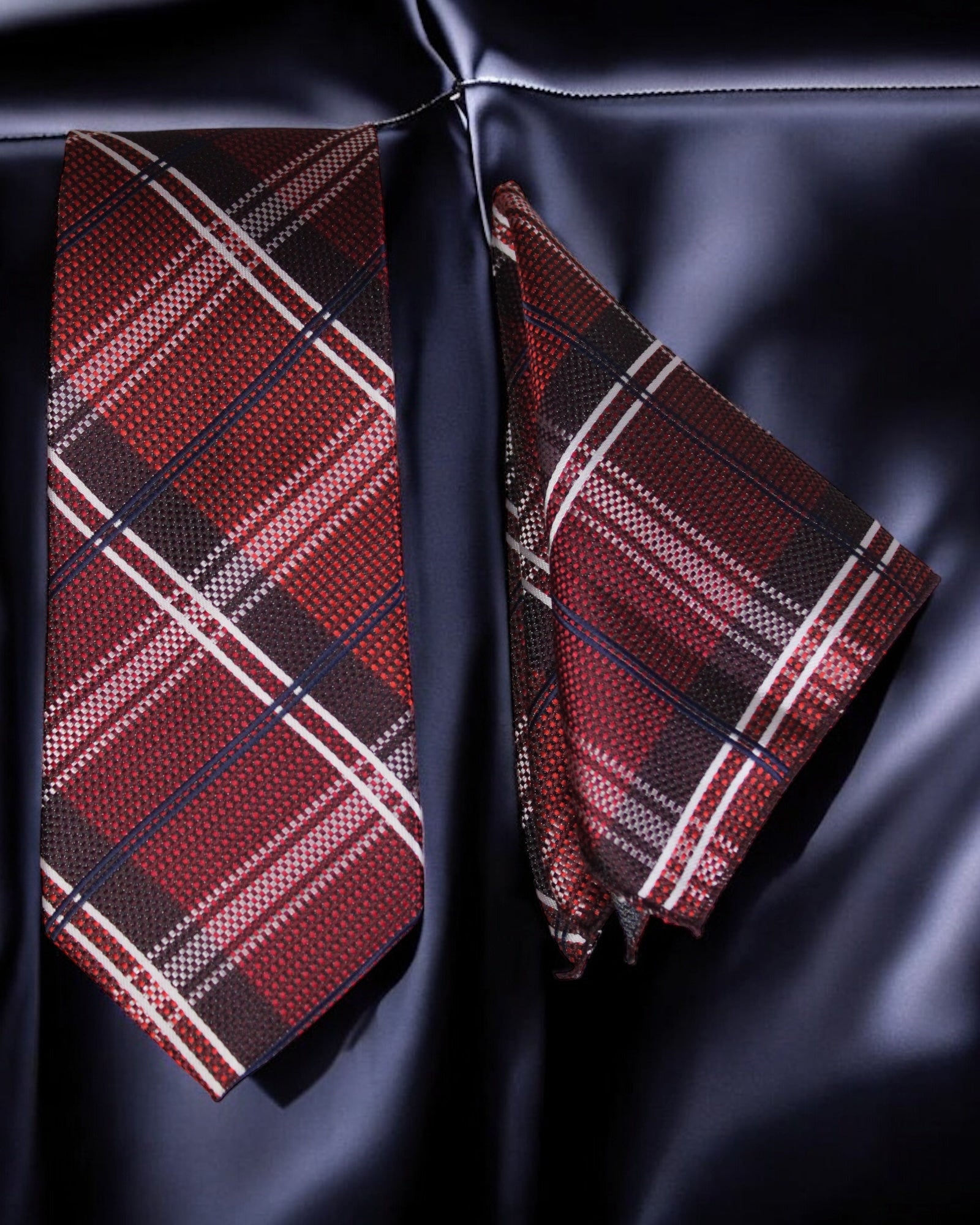 Red plaid tie and pocket square on a dark fabric background Tie Benon