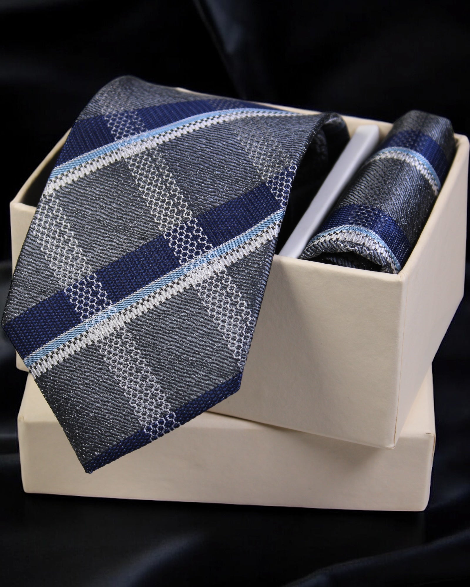 Blue plaid tie and matching pocket square in a white box on a black background Tie Benon